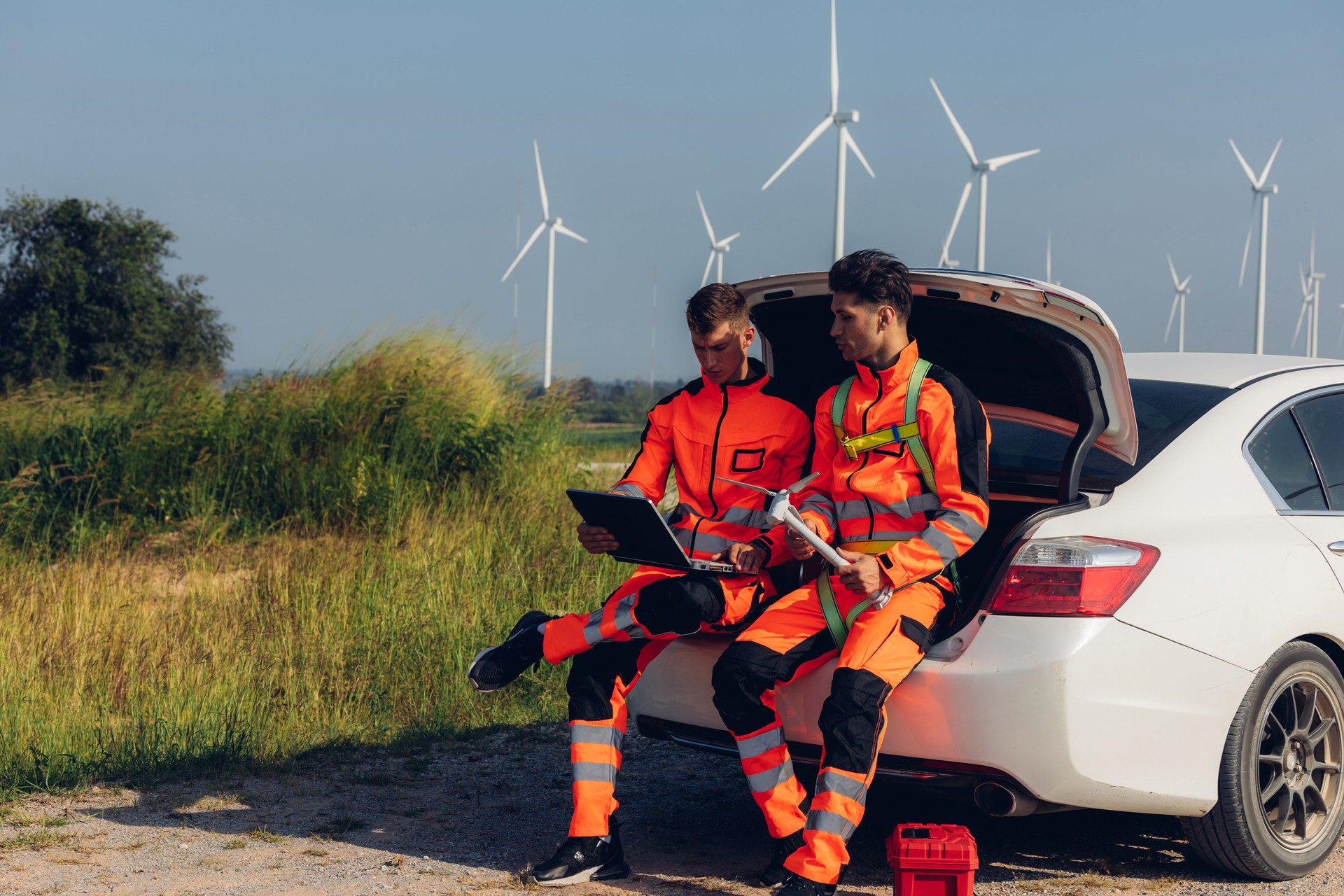 Survey Team Alternative energy for future. Engineers survey and checking wind turbines in sunset. Wind Turbine Renewable energy technology and sustainability.