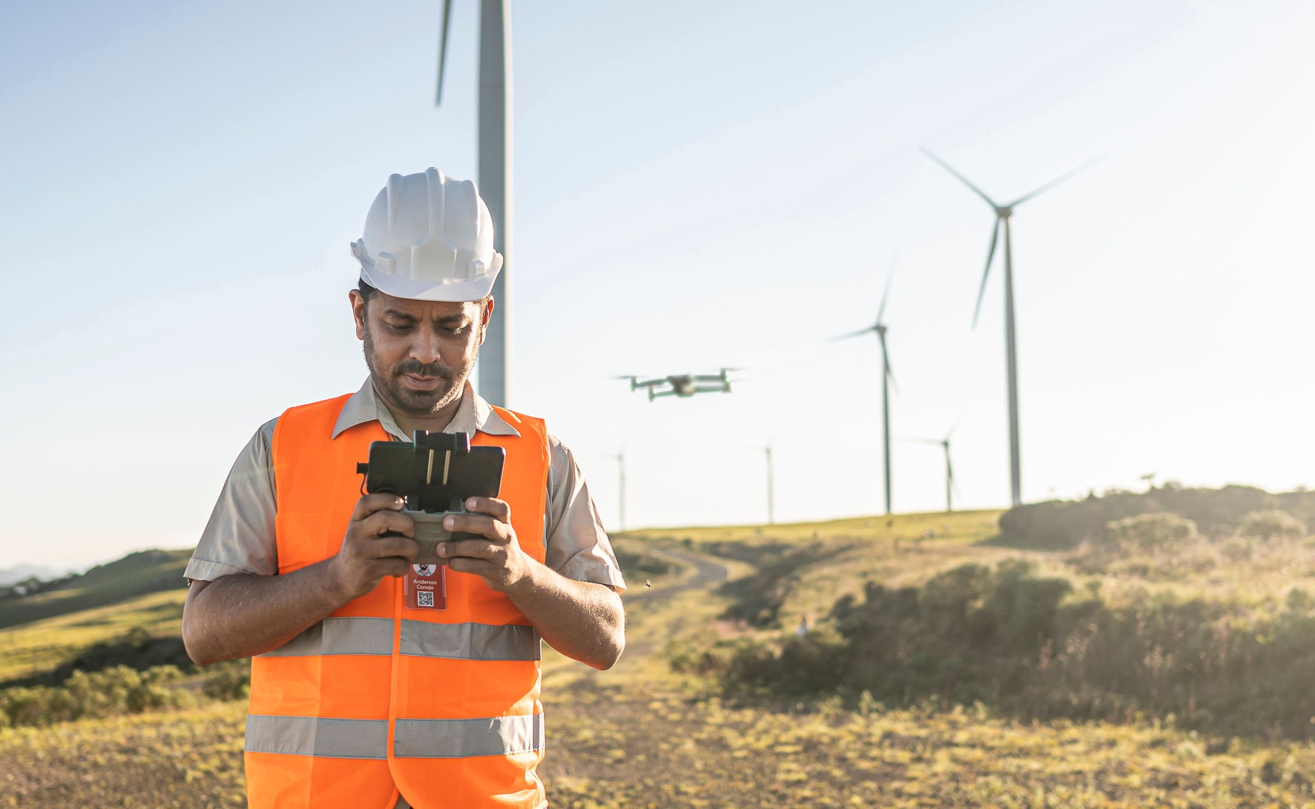 Portraits of electrical engineer/technician operating an inspection drone in wind farm park